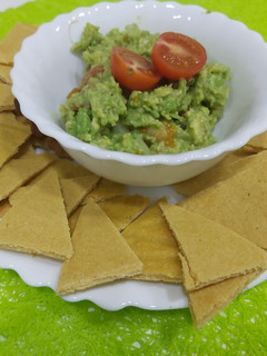 Una foto de Nachos caseros con harina de garbanzo y guacamole casero