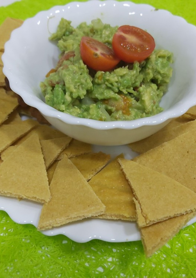Una foto de Nachos caseros con harina de garbanzo y guacamole casero