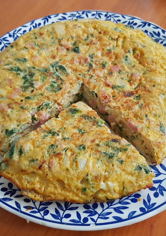 Una foto de Tortilla con papas, espinaca, jamón, queso y cebolla
