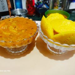 A picture of Yellow Idli with Tangy Sambhar.