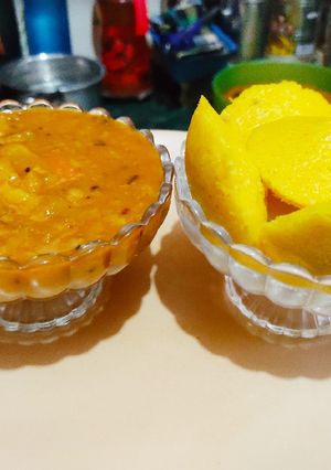 A picture of Yellow Idli with Tangy Sambhar.