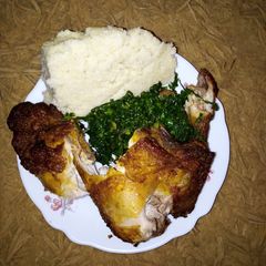 A picture of Fried chicken with ugali.