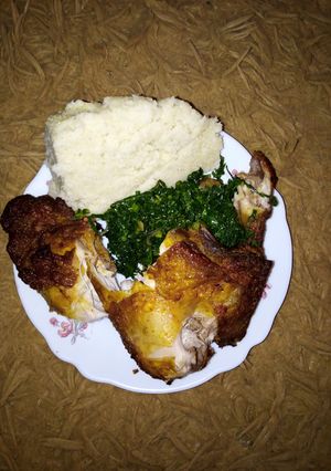 A picture of Fried chicken with ugali.