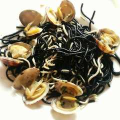 Una foto de Espaguetis negros con gulas y almejas