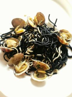 Una foto de Espaguetis negros con gulas y almejas