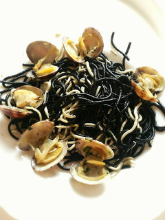 Una foto de Espaguetis negros con gulas y almejas