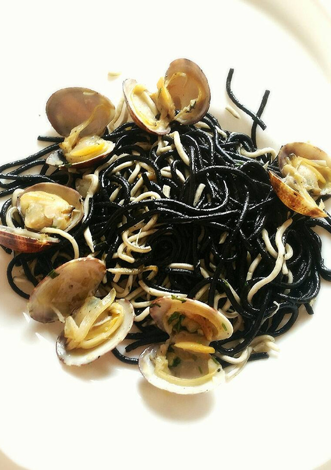 Una foto de Espaguetis negros con gulas y almejas