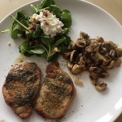 A picture of Small steaks with valerian-spinach salad and baked mushrooms.