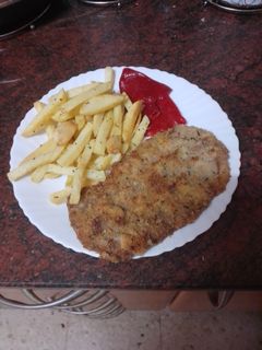 Una foto de Cachopo con papas fritas y pimientos del piquillo