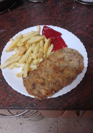 Una foto de Cachopo con papas fritas y pimientos del piquillo