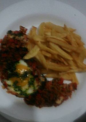 A picture of Shakshuka accompanied by French fries.