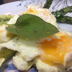 A picture of Asparagus with fried eggs.
