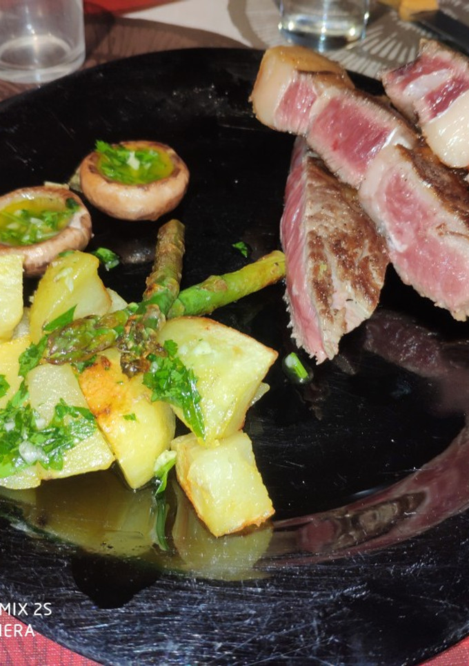 Una foto de Chuletón con guarnición de patatas boletus y espárragos