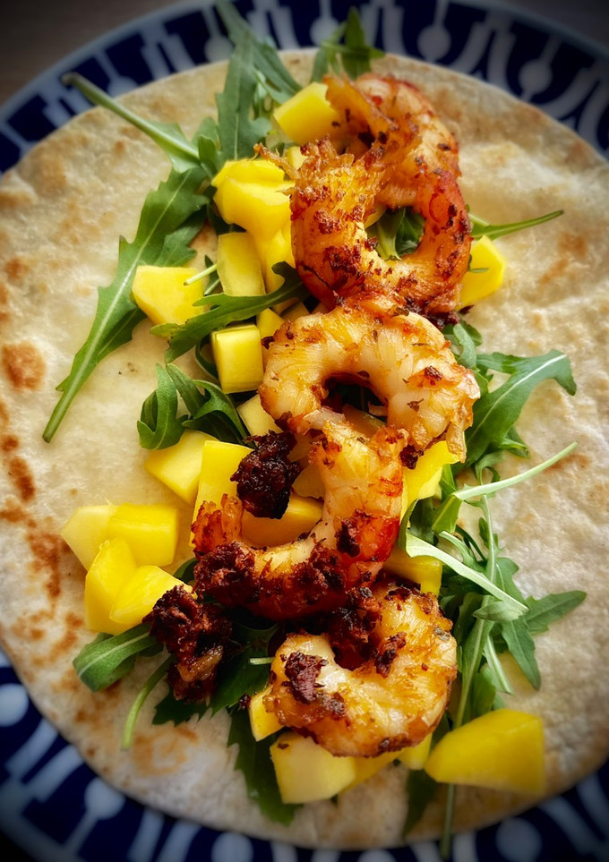 Una foto de Taco de langostinos al ajo confitado con mango