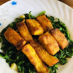 A picture of Fried fish with garlic flavour spinach.