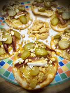 Una foto de Mini pizzas frías de queso de cabra y anchoa con cebolla caramelizada y pepinillos