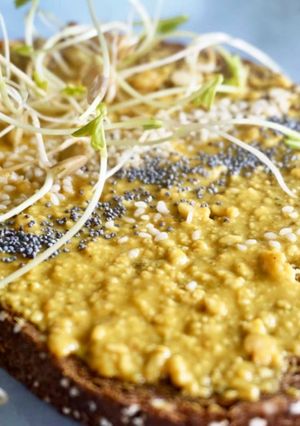 Una foto de Crema de cacahuete de orégano, cúrcuma, canela y jengibre con brotes de lentejas