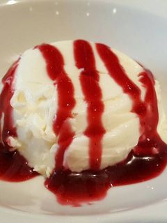 Una foto de Pannacotta con salsa de cerezas