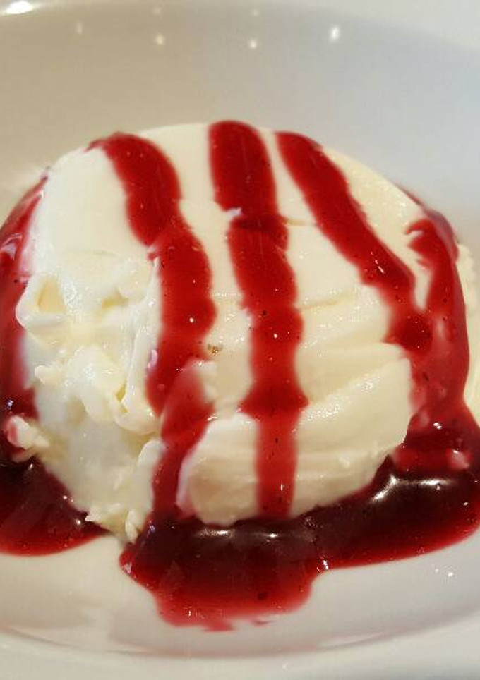 Una foto de Pannacotta con salsa de cerezas