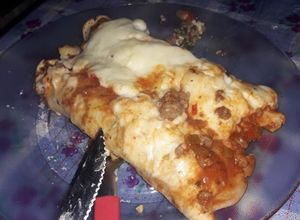 Una foto de Canelones de acelga, carne picada y sesos con salsa blanca y salsa roja