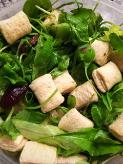 Una foto de Ensalada saludable de rúcula, aceitunas, croutons, queso y huevo