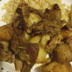 A picture of Oven Roasted Goat with Vegetables and Rice.