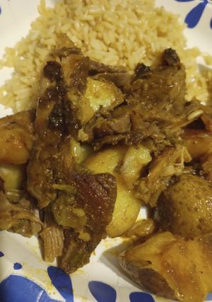 A picture of Oven Roasted Goat with Vegetables and Rice.