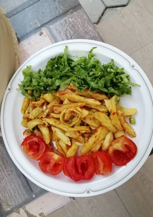 A picture of Favorite chips garnished with salad nd tomato.