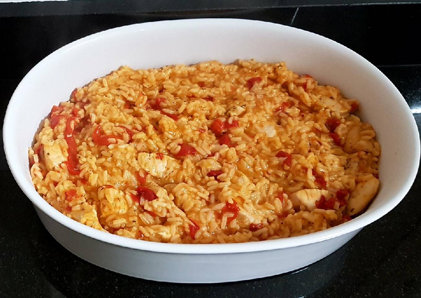 Arroz caldoso con pollo, tomate y pimientos rojos