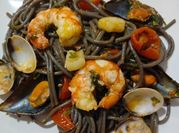 Una foto de espaguetis negros con gambas