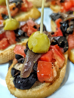 Una foto de Tosta de tomate, aceitunas y anchoa