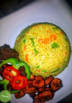 A picture of Fried rice, with peppered goat meat and dodo.