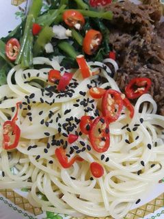 A picture of Spicy spaghetti and bbq pattie.