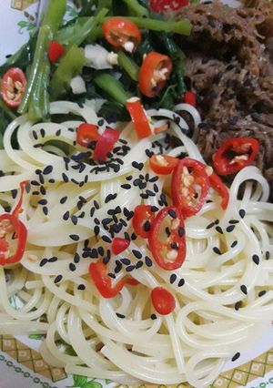 A picture of Spicy spaghetti and bbq pattie.