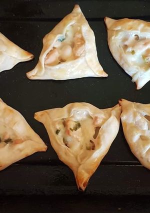 Una foto de Triangulitos de pollo, verdeo y salsa blanca