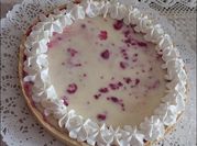 Una foto de postres con yogur y frambuesas