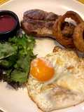 Pork shoulder steak with homemade gooseberry and beetroot ketchup, fried egg and crispy onion rings