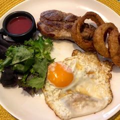 Pork shoulder steak with homemade gooseberry and beetroot ketchup, fried egg and crispy onion rings A picture of Pork shoulder steak with homemade gooseberry and beetroot ketchup, fried egg and crispy onion rings.