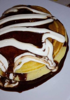 A picture of Pan cake with nutella and cream.