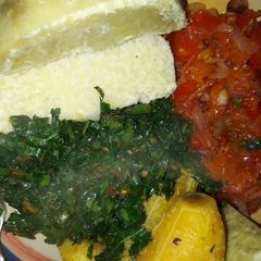 A picture of Boiled yam and plantain with sauce and vegetable.