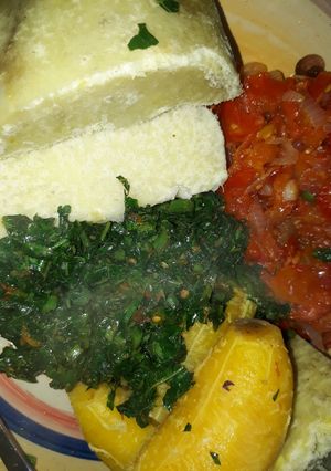 A picture of Boiled yam and plantain with sauce and vegetable.