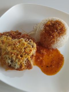 Una foto de Pollo empanizado con queso en salsa de tomate