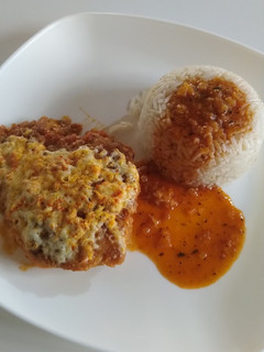 Una foto de Pollo empanizado con queso en salsa de tomate