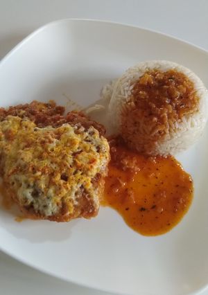 Una foto de Pollo empanizado con queso en salsa de tomate