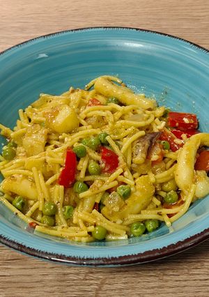 Una foto de Sepia con fideos, pimiento rojo y guisantes