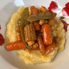 A picture of Polenta with veggies and balsamic glaze.