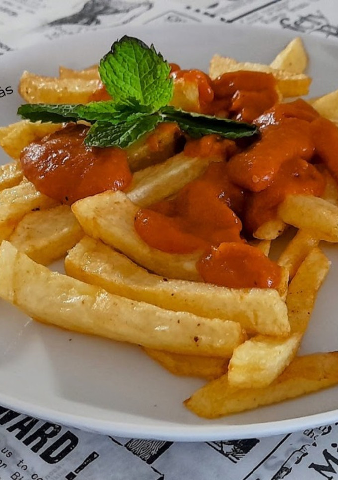 Una foto de Patatas fritas con tomate casero