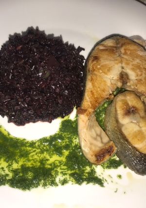 Una foto de Salmón en salsa pesto de eneldo, con arroz negro