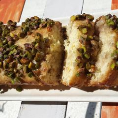 A picture of Orange and Rose Syrup Cake with Pista Crunch.