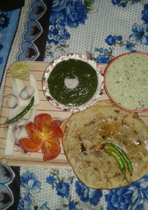 A picture of Bajra ke roti or saag with rayta or salad.